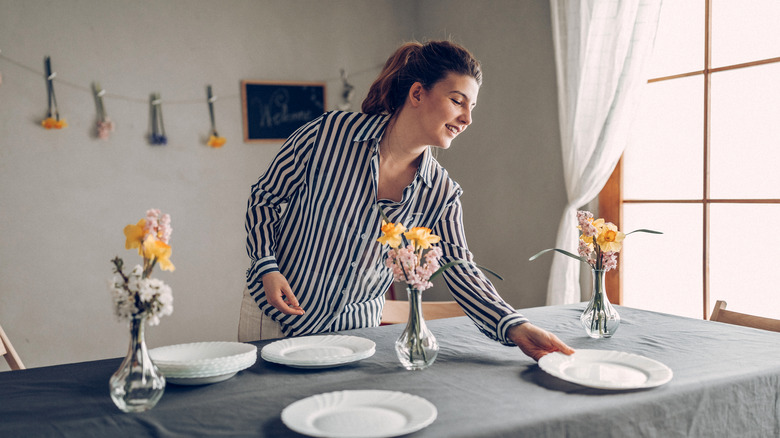 a woman preparing dinner table