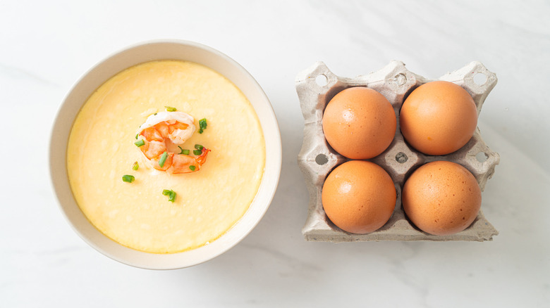 A bowl of chinese steamed custard, topped with shrimp and spring onions