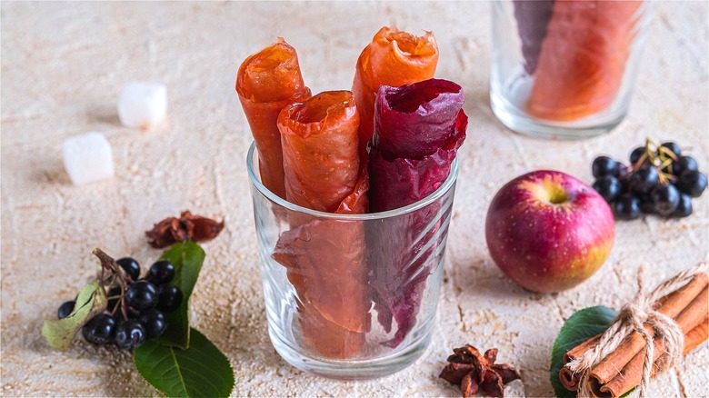 Rolls of fruit leather in a clear glass.