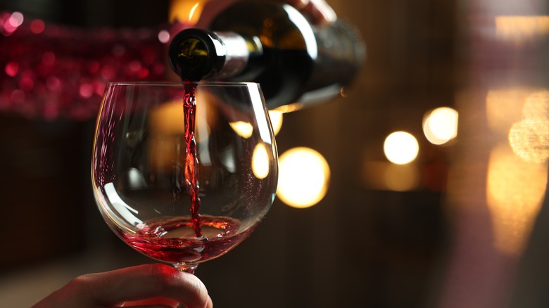 Close-up of red wine pouring into glass