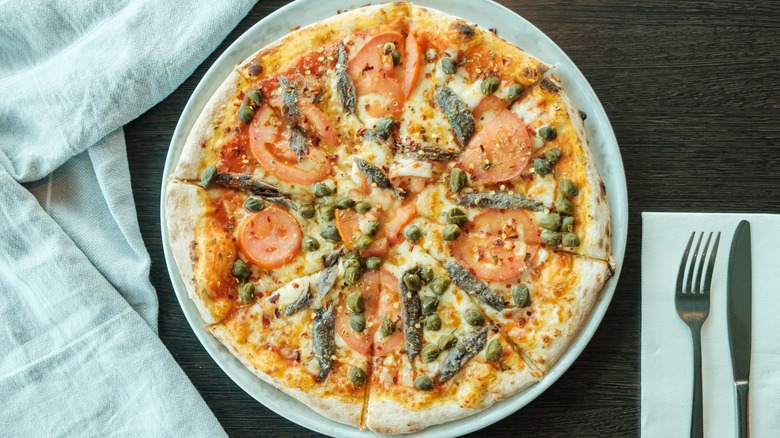 Pizza with anchovies, tomato, capers