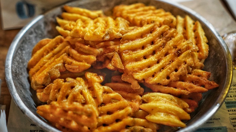 Metal bowl of waffle fries
