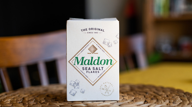 A box of Maldon coarse sea salt sits on a kitchen table