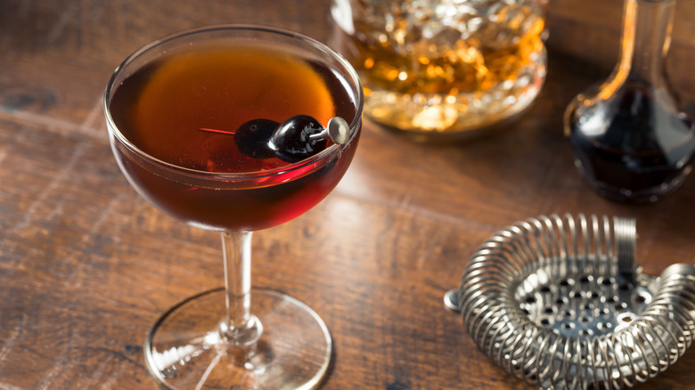 manhattan cocktail with black cherry garnish