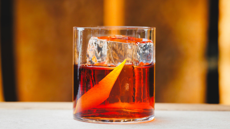 Glass of negroni cocktail garnished with orange