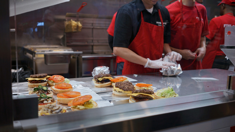 five guys workers making burgers