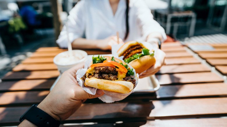 two people eating fast food burgers