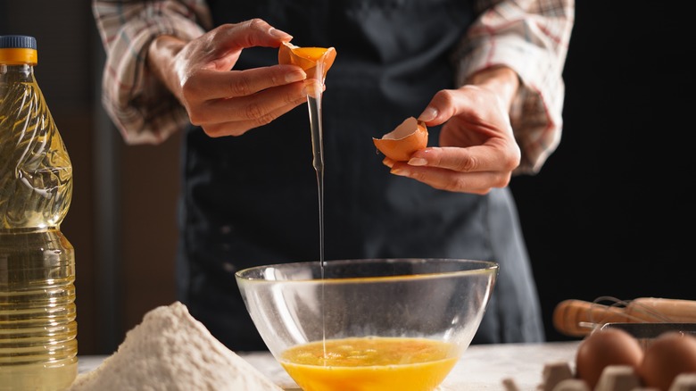 person using egg shells to separate eggs