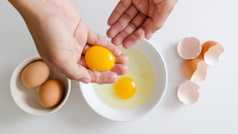 person separating eggs with hands