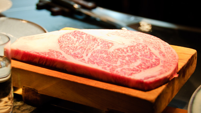 Thin cut of marbled raw Wagyu steak on a board