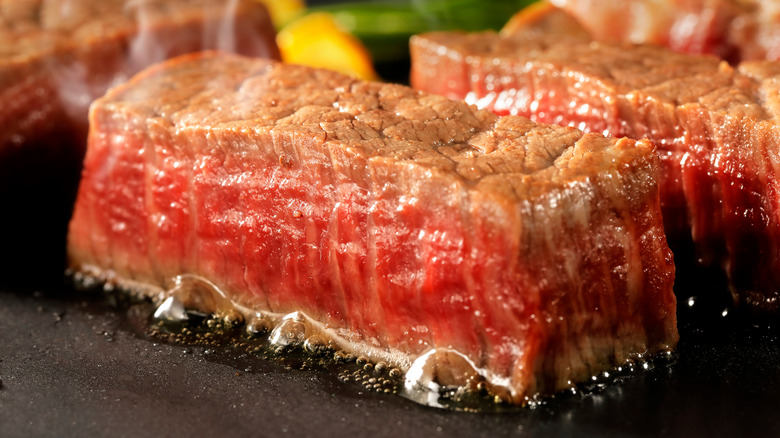 Wagyu steak being grilled on an iron plate