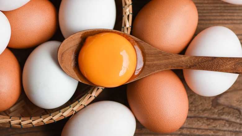 egg yolk on spoon over bowl of eggs