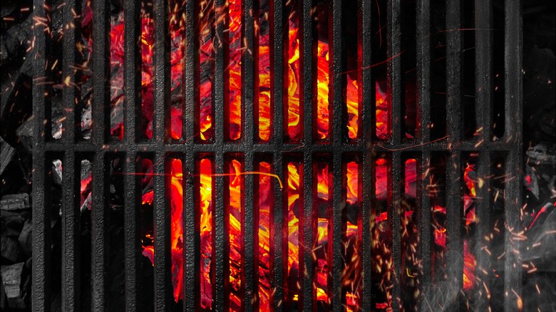 cast iron grill with flaming coals