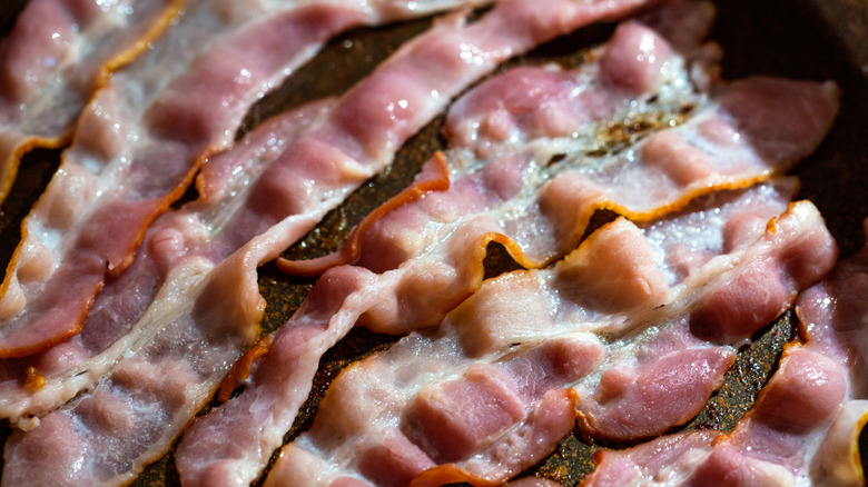 Slices of bacon crisp up in a pan