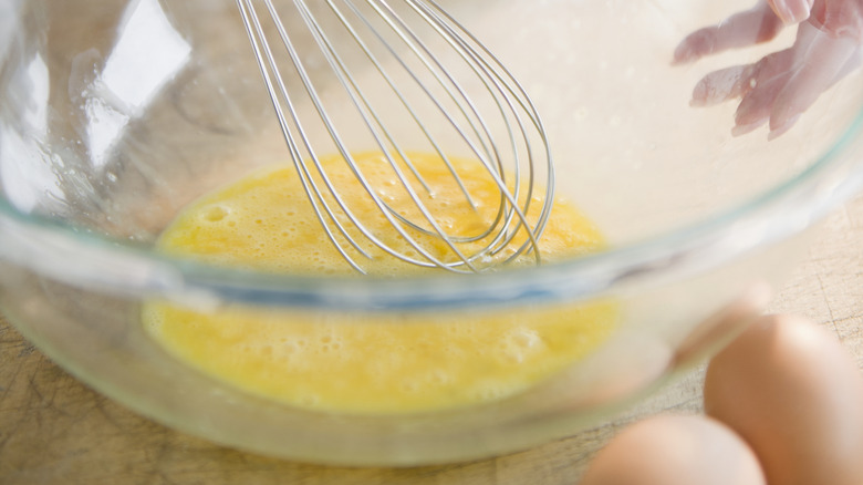 A woman whisks eggs