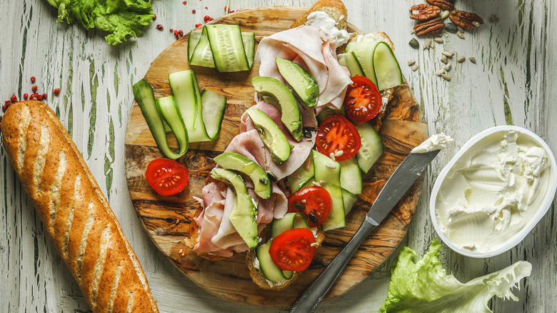 sandwich fillings on a table next to a baguette