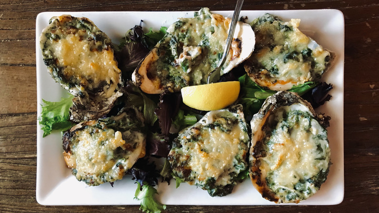 A plate of Oysters Rockefeller with a slice of lemon