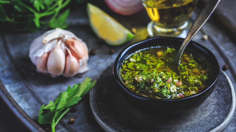 Chimichurri sauce with garlic, herbs, and lime on the side.