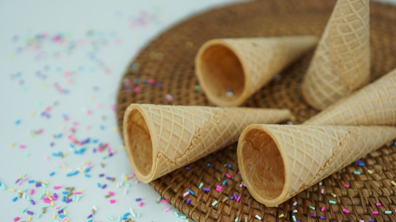 Empty ice cream cones on a table with sprinkles