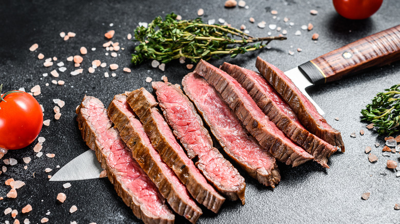 flat iron steak with knife and herbs