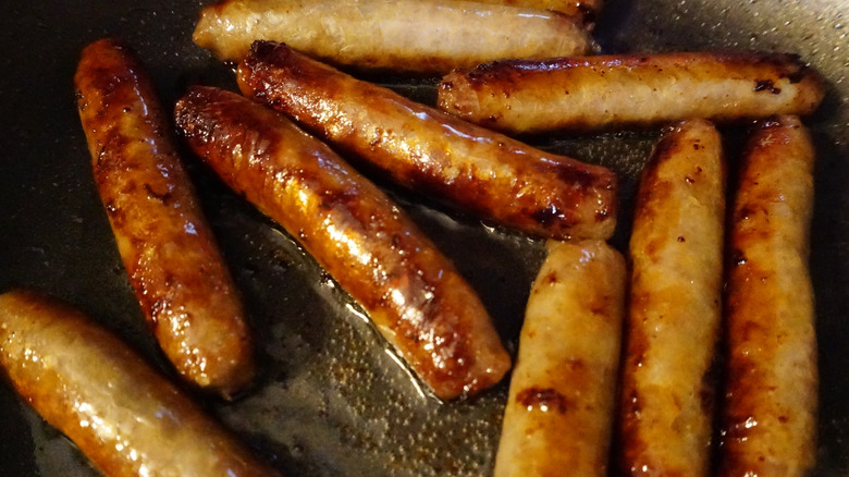 Breakfast sausages sizzling in a pan