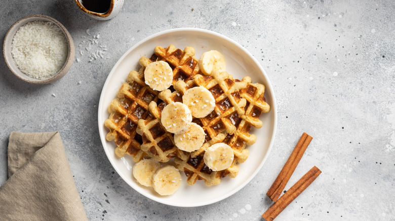 Waffles topped with cinnamon, bananas, and date syrup