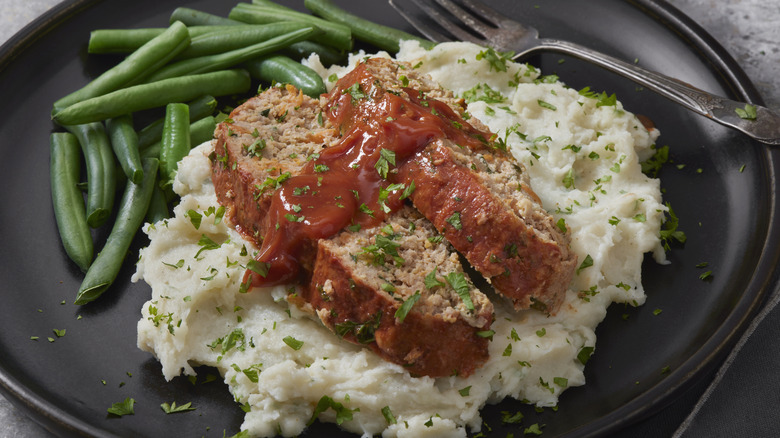 meatloaf with garnish on a cutting board