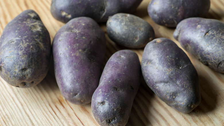 purple potatoes on wood board