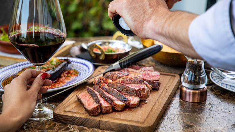 Couple enjoying a sliced steak and other dishes