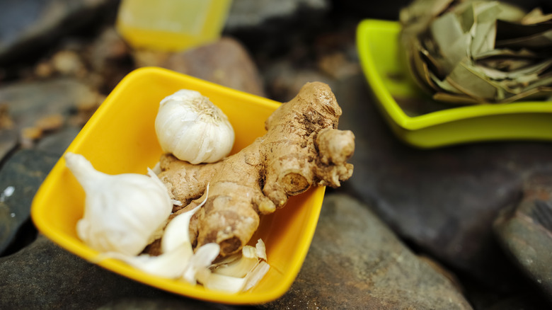 Whole garlic and ginger in yellow dish