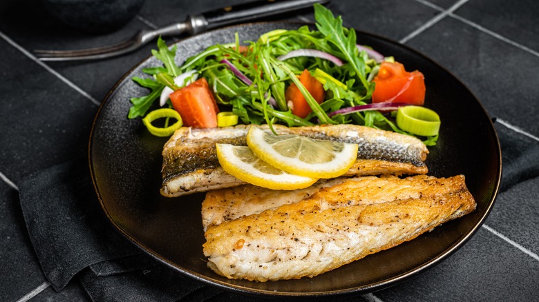 cooked bass fillets with side salad