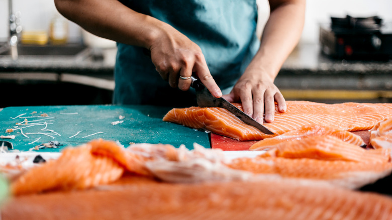 chef slicing salmon fillets