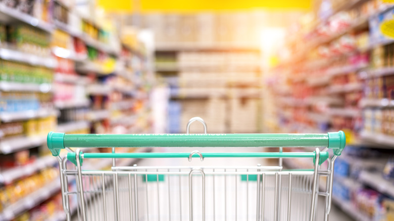 Empty grocery cart in store aisle