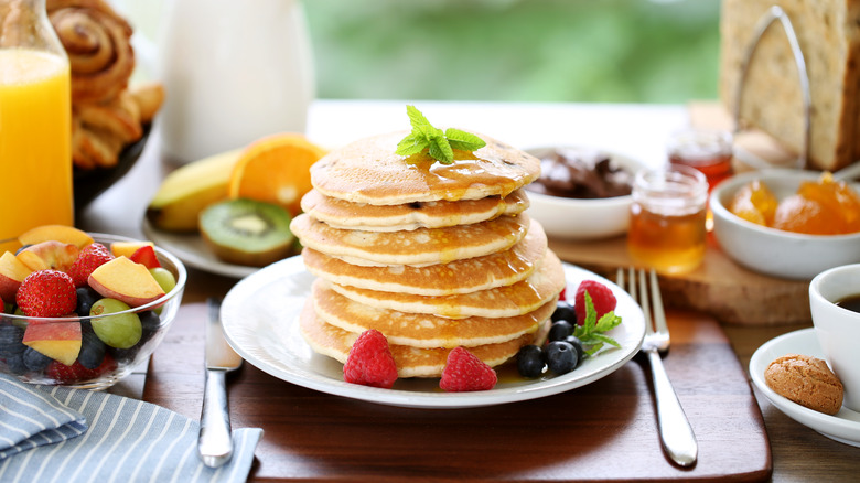 Breakfast table with a tall stack of pancakes