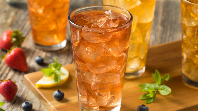 glasses of sweet tea with lemon, blueberries, mint, and strawberries