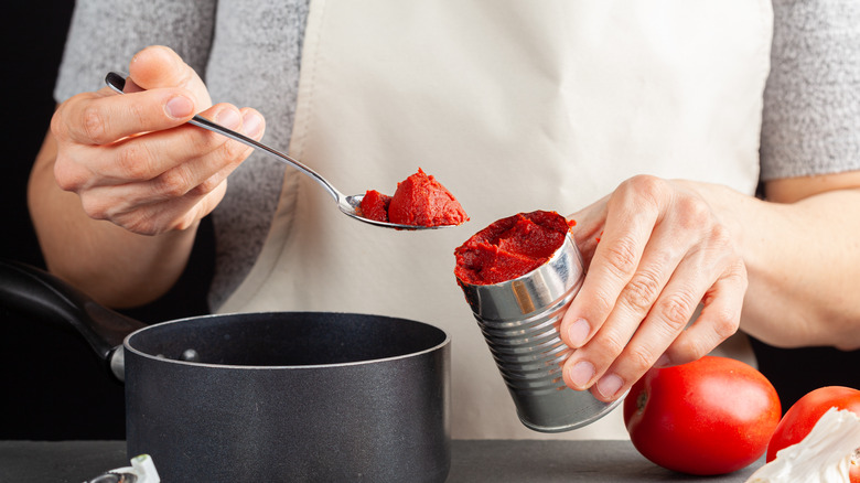 Person cooking canned tomatoes