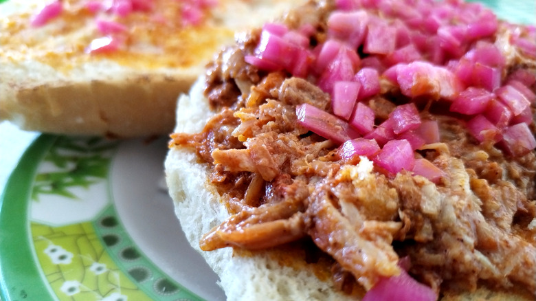 Cochinita pibil with pickled onions on a roll