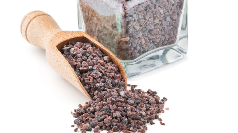 Black Salt in jar and wooden scoop