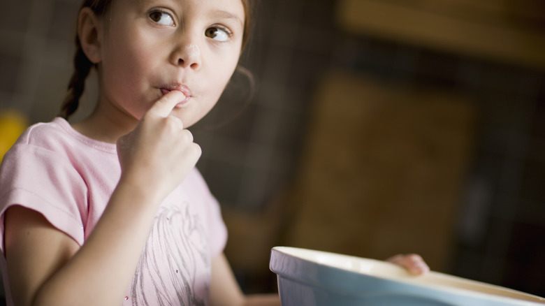 girl tasting cake batter