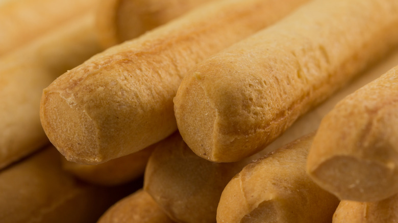 A group of fresh breadsticks sit close together