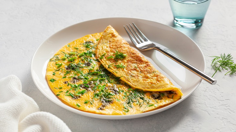 omelet with herbs on plate with fork
