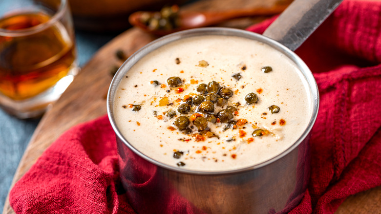Creamy peppercorn sauce for steak with glass of Scotch whisky