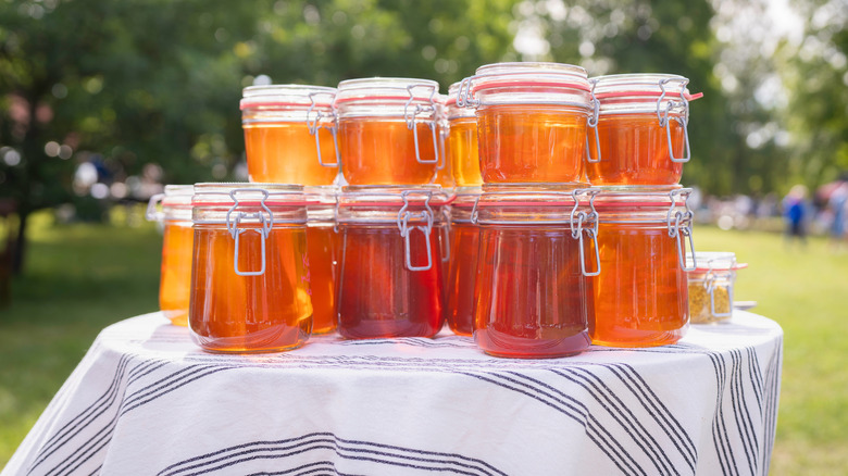 A variety of honey jars displayed on an outdoor table