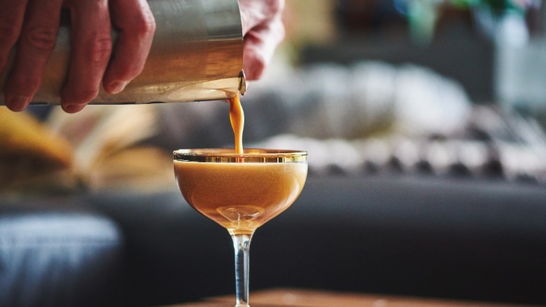 Hands pouring an espresso martini 