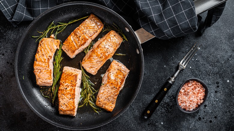 Salmon fillets in a pan with rosemary