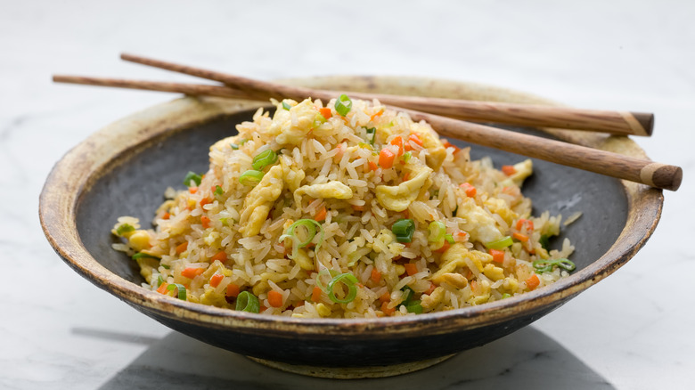 fried rice in a bowl with chop sticks