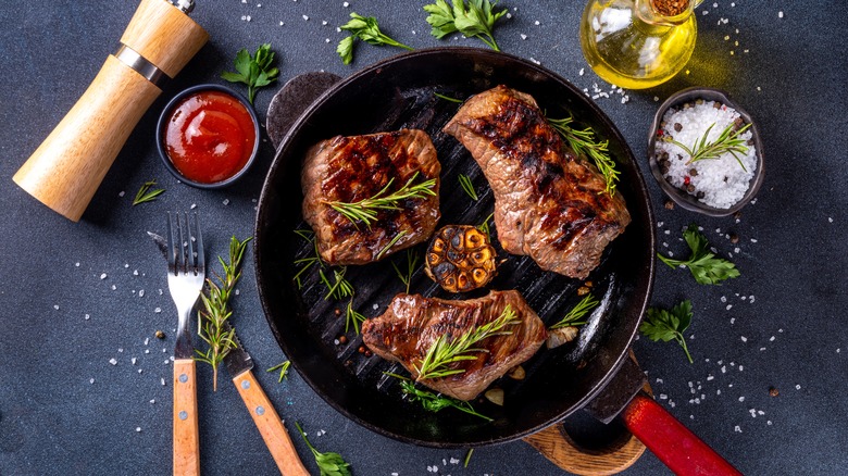 steaks in pan with seasonings