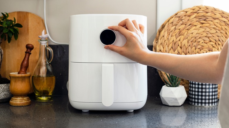 hand turning an air fryer knob