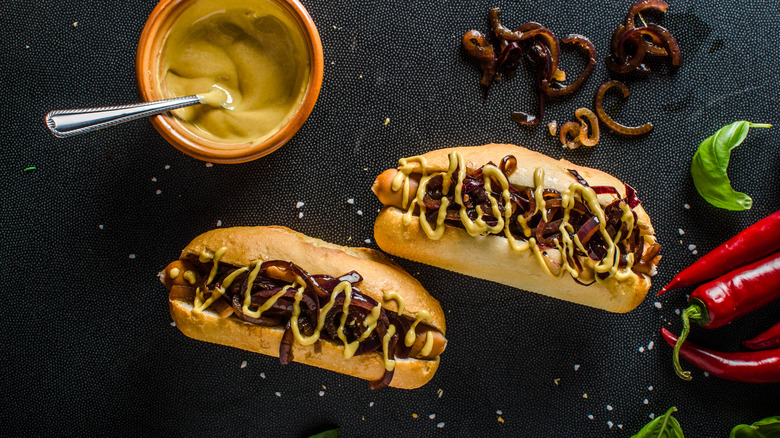 Sausage in bun with caramelized onion and mustard