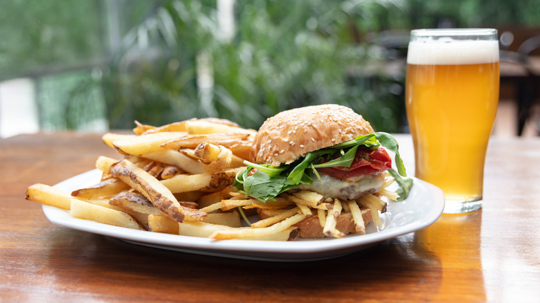 a plate of fries and a burger with a glass of beer